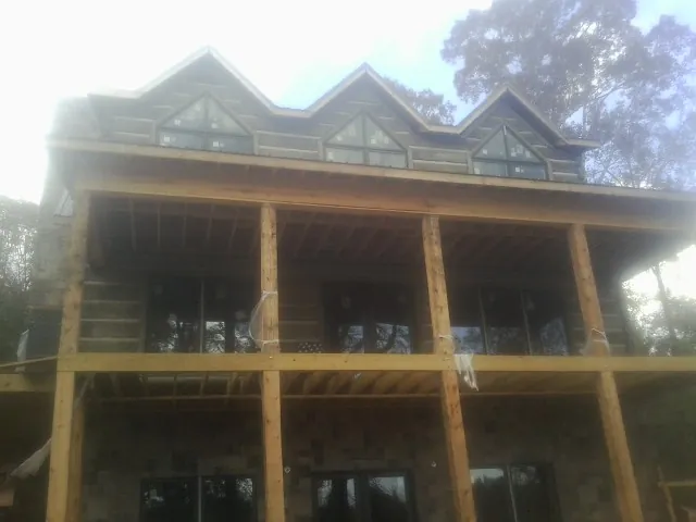 Dormers and porch framing on a large log home under construction — Roof Coating work by our crew in Sun Valley