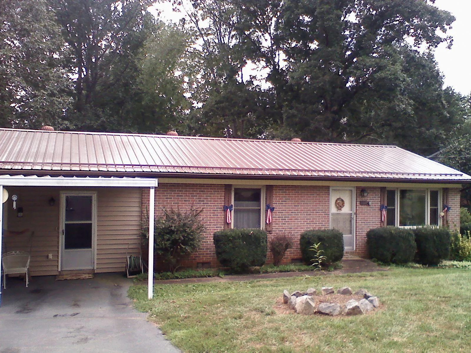 Bronze metal roof and carport on a brick ranch home — Roof Repair work by our crew in Sun Valley